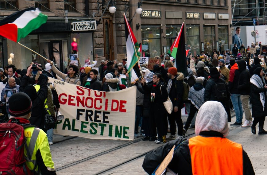 a group of people walking down a street holding flags