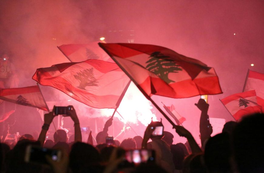 A Crowd Gathered in a Concert Waving Flags