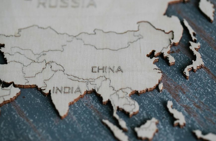 Detailed view of Asia carved on a wooden map, highlighting China and India.