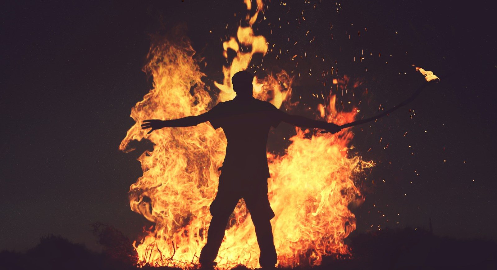 person standing in front of fire during night time