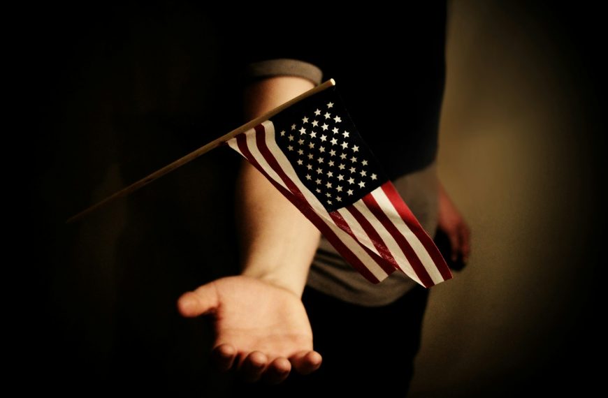 person with open palms below USA flaglet