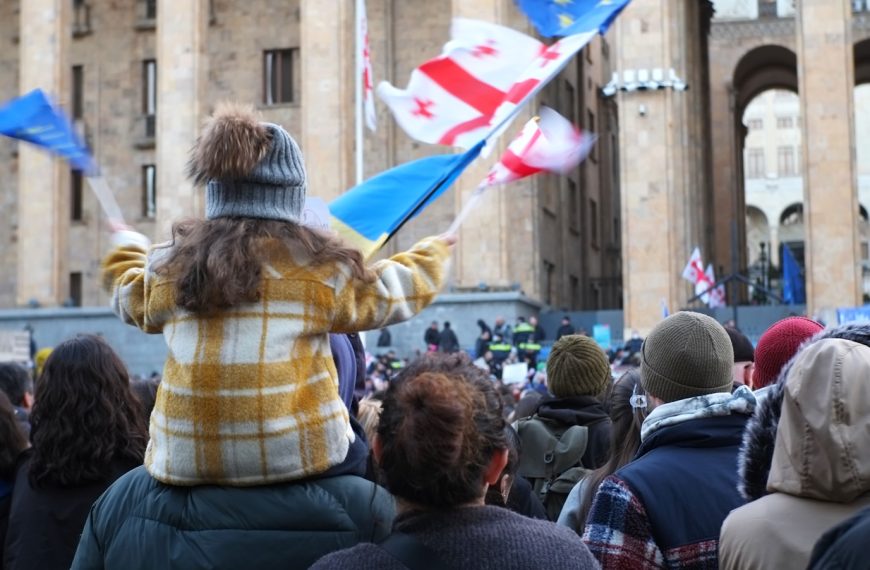 a woman holding a flag in front of a crowd of people