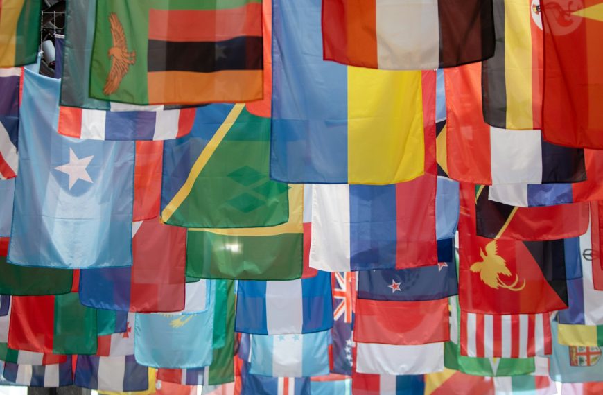 a bunch of flags hanging from a pole