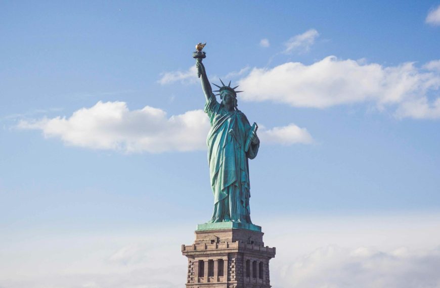 Statue of Liberty, New York under white and blue cloudy skies