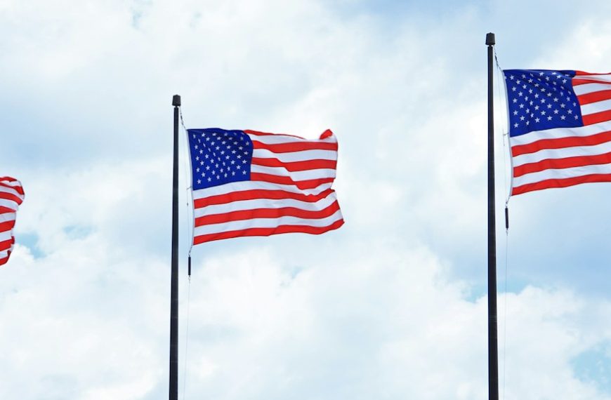three american flags are flying in the wind