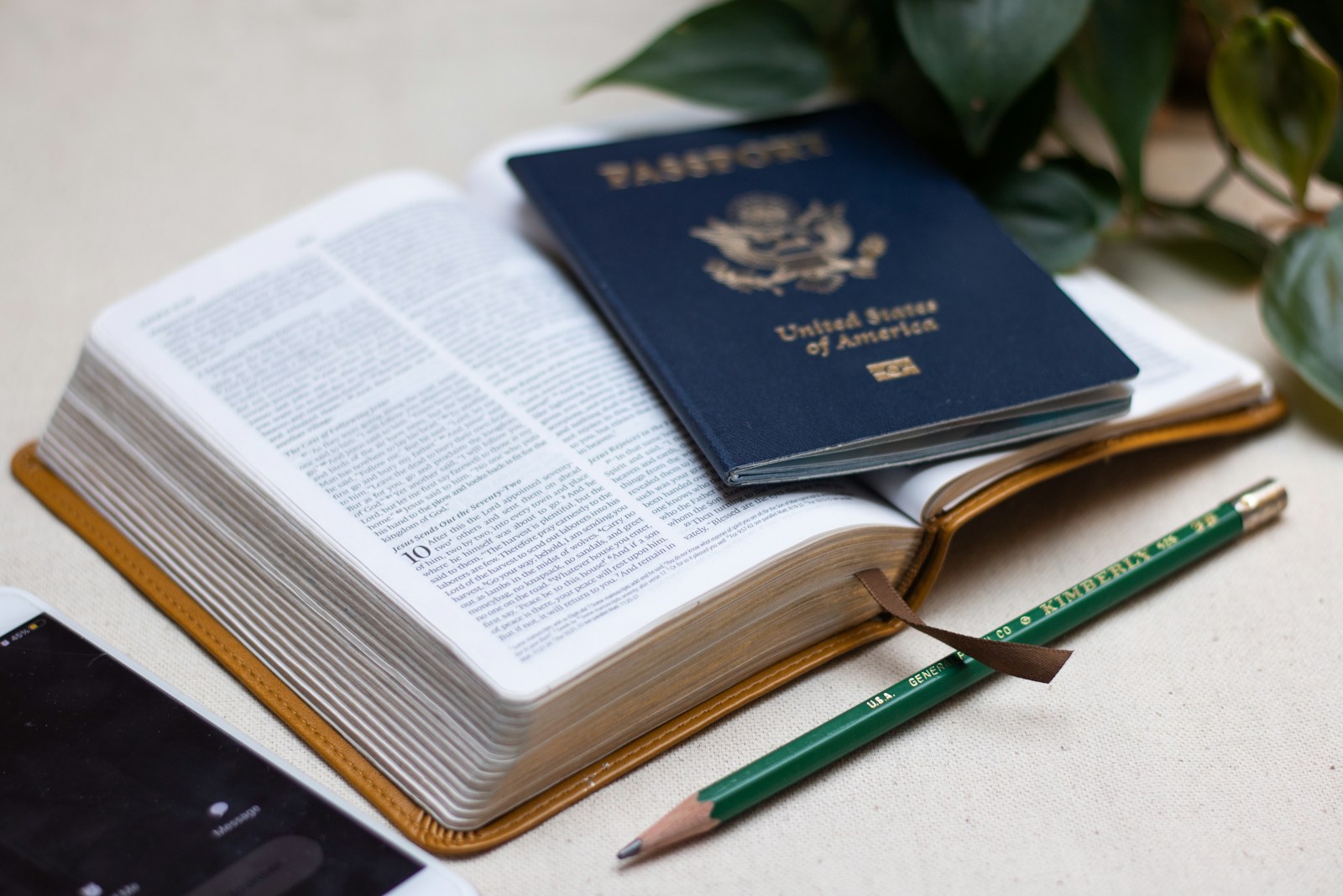 a passport a cell phone and a pen on a table