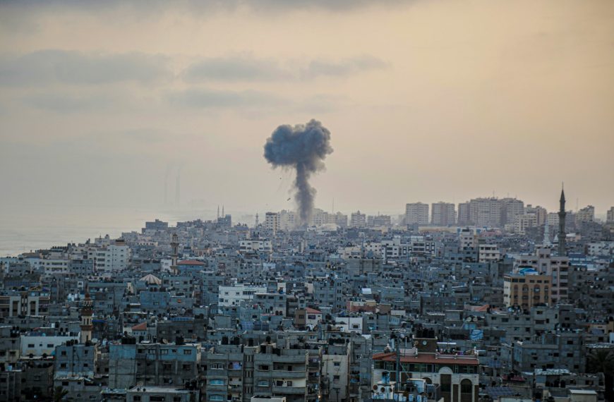 smoke billows from a factory in a city