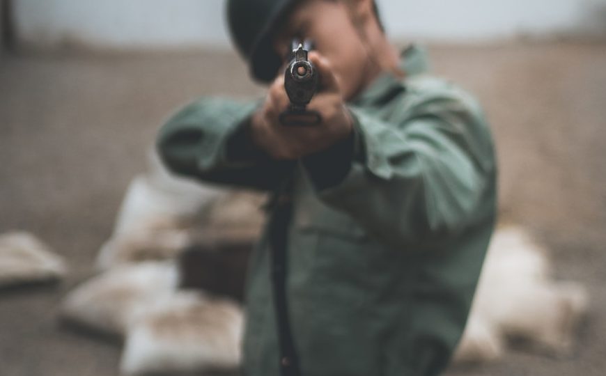 soldier pointing rifle during daytime