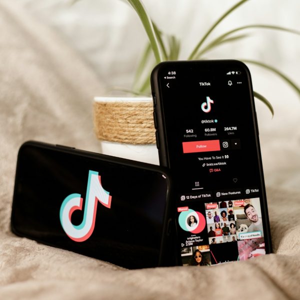 a couple of cell phones sitting on top of a bed
