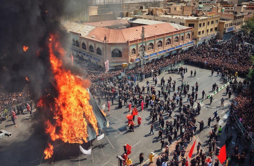 group of people standing surrounded on burning tipi tent during daytime
